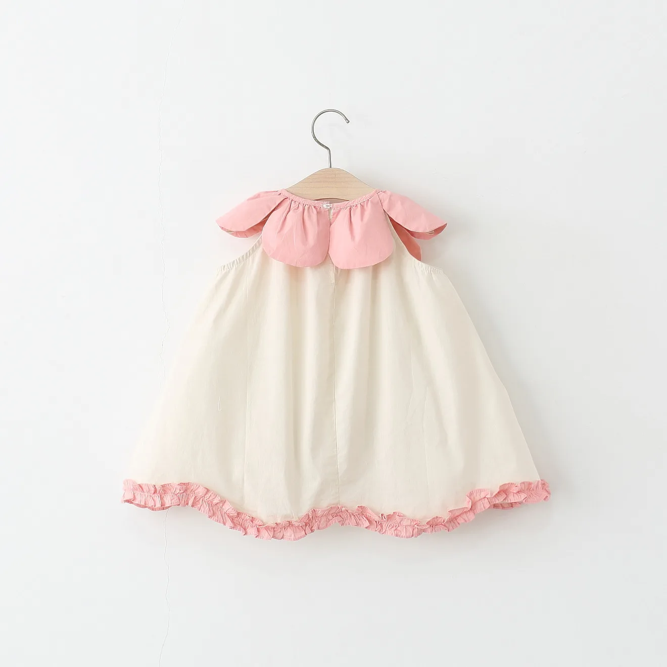 Detalle de cuello de muñeca y flores del vestido