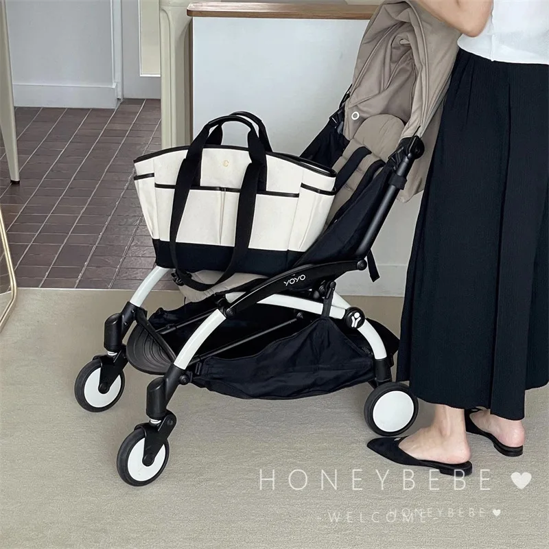 Vista frontal de la bolsa de mamá OIMG mostrando su diseño cruzado y bolsillos externos