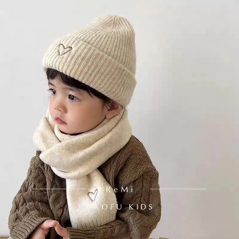 Niña con gorro y bufanda tejidos de lana