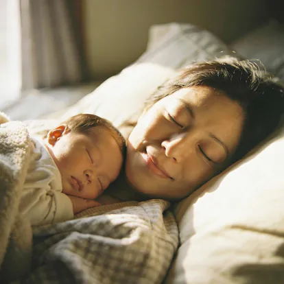 Madre descansando con su bebé recién nacido durante el postparto.