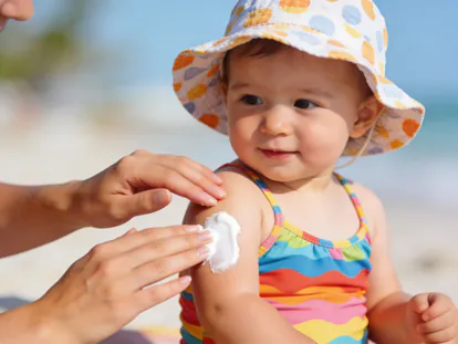 Aplicación de protector solar a un bebé antes de ir a la playa.